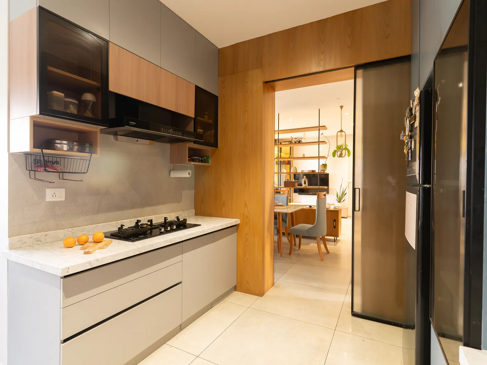 Grey and oak kitchen with sliding glass door to dining — Amlan's Residence